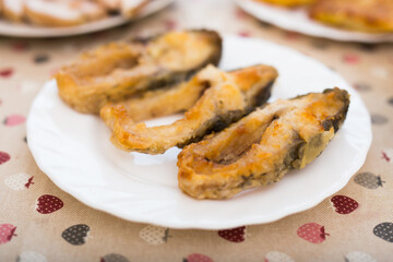 pieces of the middle part of the carp baked on a white plate