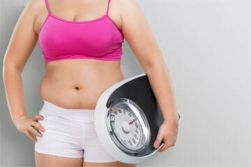 Obese woman against light background. Weight loss surgery