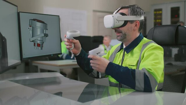 Metaverse virtual worlds concept. Mature industrial engineer in vr headset working on 3d model using computer and joysticks