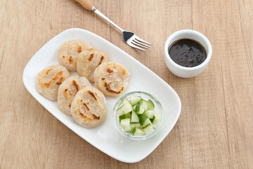 Pempek Tunu or Pempek Panggang, traditional food from South Sumatra, Indonesia. This fish-based food is very popular. Served with cuko sauce.
