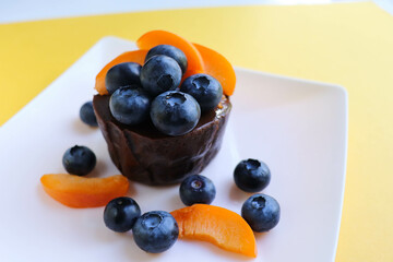 summer dessert. chocolate biscuit with blueberries on a white plate