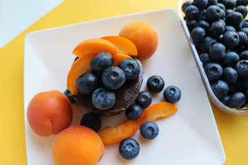 summer dessert. chocolate biscuit with blueberries on a white plate