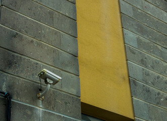 CCTV security camera system being used for surveillance purposes placed on a brick wall with copy...