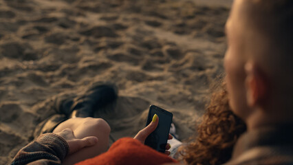 Unrecognizable couple enjoying vacation on sandy morning sunrise beach closeup
