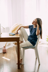 A high school student sits at home at her desk, takes a break before preparing for classes or exams, studies at home. The concept of training and education