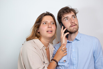 un couple d'amis est en communication téléphonique avec un smartphone. Isolé sur fond blanc