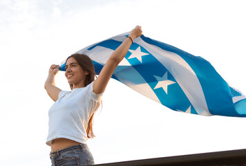 latina girl from guayaquil smiles as she holds the city's flag in honor of the independence...