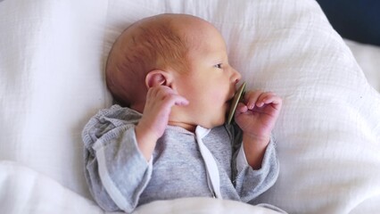 newborn with pacifier. baby close-up with a pacifier lies in bed at lifestyle home indoors. happy family maternity hospital kid dream concept. newborn baby boy with pacifier close-up