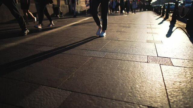 Silhouettes of legs walking. Shadows of people walking in a street of the city.