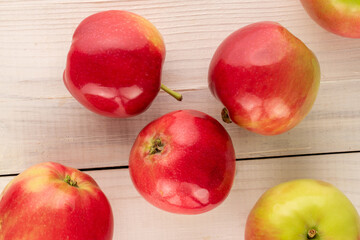 Several juicy red apples on a wooden table, macro, top view.
