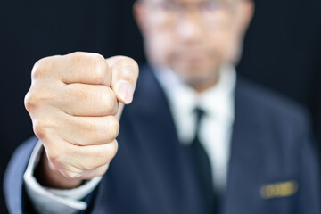 Businessman clenching his fists to show confidence in business