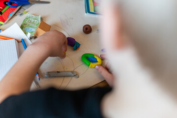 Fototapeta premium Poland, Krakow – April 03, 2022: Child is sculpting a figure from plasticine at the table