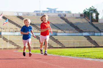 Fototapeta premium Child running in stadium. Kids run. Healthy sport.