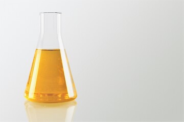 Unrefined sunflower oil in chemical flask on desk background.
