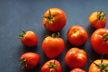 Fresh organic tomatoes, picked from the garden, on dark background. Selective focus.