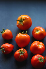 Fresh organic tomatoes, picked from the garden, on dark background. Selective focus.