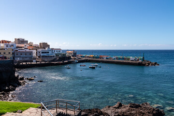 Panoramic view on small fishermen coastal village Los Abrigos, Tenerife, Canary Islands, Spain, Europe, EU. Coastline of Atlantic Ocean. Small boats floating in the turquoise water of the marina