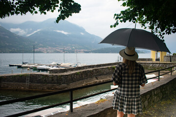 Female Tourist with Umbrella exploring Lake Como Italy during the rainy season
