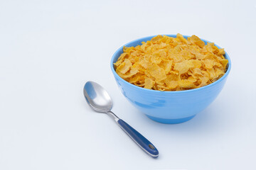 Breakfast cereal and spoon on white with copy space