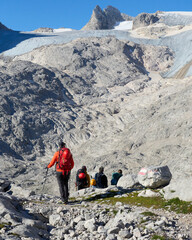 eine gemischte Gruppe Bergsteiger und Bergsteigerinnen wandern in Richtung Hallstätter Gletscher am Dachstein mit hoher Dirn im Hintergrund