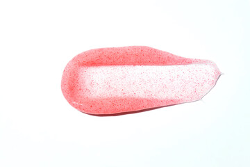 Scrub stroke isolated on white background. Pink exfoliation cream smear smudge sample. Peeling scrubbing face or body skincare product swatch. showcase of the product