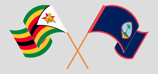 Crossed and waving flags of Zimbabwe and Guam