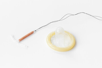 Fototapeta na wymiar T-shaped intrauterine birth control device with condoms. Contraception concept