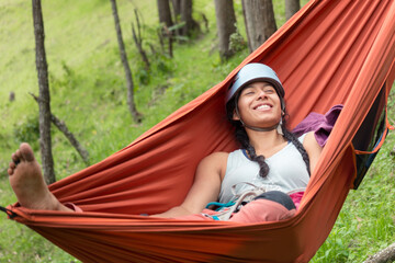 Adventurous joyful woman in a hammock outdoors 