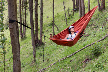 Fit hiker relaxing in a hammock in the forest