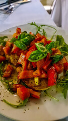 Bruschetta toast with fresh tomatoes, basil leafs and olive oil served on a white plate. Mediterranean cuisine. Eating lunch in restaurant in the streets of Rome, Lazio, Italy, Europe, EU
