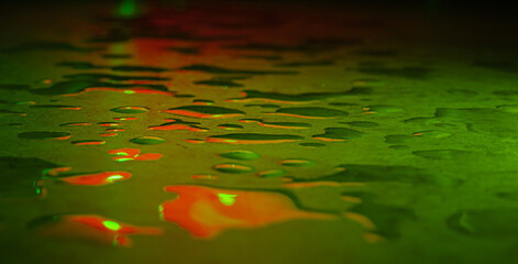 Beautiful macro photo of water drop reflection, lying on surface, front view. Close up of liquid with side lighting from displays.