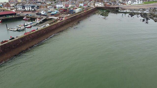 Drone view of the sea coast near the pier with the town in the background