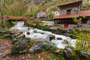 Fototapeta na wymiar Casa en un pueblo de montaña junto a un río en otoño 