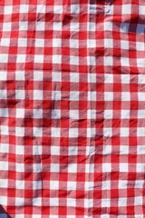 Red checkered picnic tablecloth as background, top view