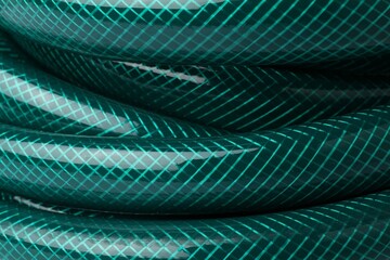 Green rubber watering hose as background, closeup