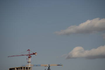 unfinished building against the background of the evening sky for banner, background, postcard, mail beautiful glass building, apartment building, cranes construction	
