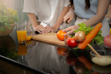 The hand of woman cutting the orange preparing for healthy food.  Couple lover preparing healthy breakfast.