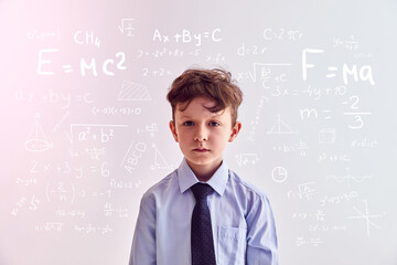 Funny kid against colored backgrounds with mathematical formulas