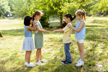 Naklejka na ściany i meble Group of asian and caucasian kids having fun in the park