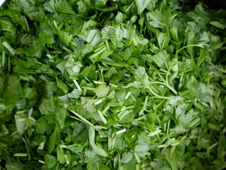 Finely chopped parsley on a plate. Ingredients for salad preparation. Preparation of vegetarian vitamin-containing food.