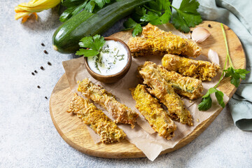 Healthy tasty snack, summer food. Zucchini fries. Crispy Zucchini sticks in breadcrumbs, with cheese with garlic yogurt sause. Copy space.