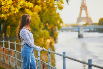 Beautiful young woman enjoying bright autumn day in Paris, France