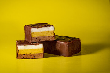 Rectangular candies with puff souffle filling, covered with dark chocolate. Multi-colored, puff souffle, covered with dark chocolate, whole and cut.