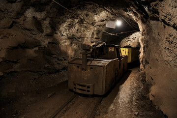Dirty electric locomotive in the mine underground. Technologies of underground mining. Industrial...