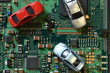 Toy cars on electronic board and microchip. Conceptual image for semiconductor shortage disrupting...