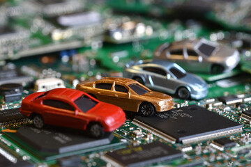 Toy cars on electronic board and microchip. Conceptual image for semiconductor shortage disrupting...