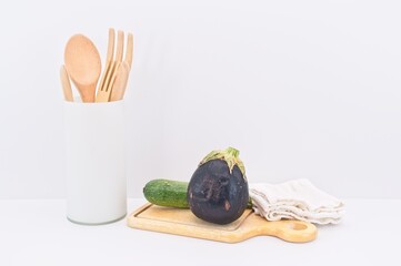 ortaggi da agricoltura biologica, utensili da cucina con tagliere in legno e canovaccio bianco su tavolo bianco - concetto di sana alimentazione
