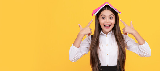 happy teen girl in school uniform pointing finger book on head, learn. Portrait of schoolgirl student, studio banner header. School child face, copyspace.