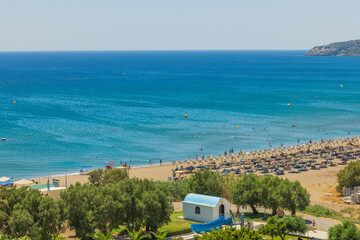 Beautiful view of Mediterranean sea sand beach with sunbeds and sun umbrellas on background....