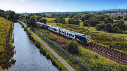 Aerial drone shot of a moving train near a river